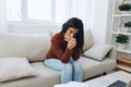 A woman looks at an engagement ring in her hand with sadness and tears, divorce and loss of a partner, breakup, unhappy