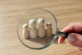 Woman looks at figures of family members through loupe