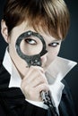 Woman looks through handcuff as magnifying glass