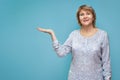 A woman in a blouse and jeans stands on a blue green background Royalty Free Stock Photo