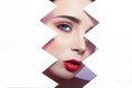 Woman looks into the hole of torn paper, bright beautiful makeup, big eyes and lips, bright lipstick, professional cosmetics and Royalty Free Stock Photo