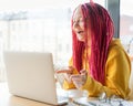 Woman looks at laptop and laughs, says yeah. Online chat, stream. Girl with long pink hair, designer, creative specialist,
