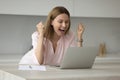Woman looks at laptop scream with joy while read news