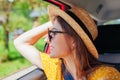 Woman looks out of car window. Passenger feels free and happy on road trip. Spring vacation Royalty Free Stock Photo