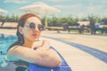 Woman looks out of pool, hanging on the railing. Royalty Free Stock Photo