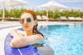 Woman looks out of the pool, hanging on the railing. Royalty Free Stock Photo