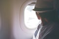 Woman looks out the window of an flying airplane wings view. Young passengers are traveling by plane, watching the sky from above Royalty Free Stock Photo