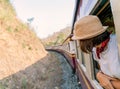 Woman looks out from window traveling by train in Thailand Royalty Free Stock Photo