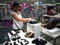 A woman looks at a pair of shoes in the shoe department of SM City mall in Taytay City, Philippines.