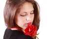 Woman looks at red rose on her shoulder Royalty Free Stock Photo