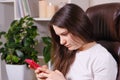 The woman looks at the screen of the phone, tilting her head down, tension of the muscles of the neck and poor posture.