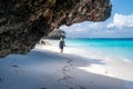 Woman looks for seashells on the beach in Zanzibar, Tanzania Royalty Free Stock Photo