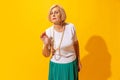 One annoyed senior woman in summer style outfit isolated on bright yellow background. Concept of beauty, emotions Royalty Free Stock Photo