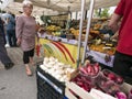 Woman looks at vegetables on open air market of briancon in the french haute provence