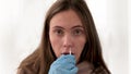 Woman takes swab from nasal mucosa using medical tampon