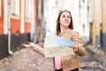 Woman lost in the city. Confused traveler holding map.