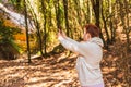 woman lost in the forest, searching for reception signal for her smart phone. accident on vacation.