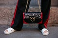 Woman with Love me tender Pinko black and red bag before Prada fashion show, Milan Fashion Week street style