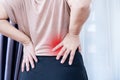 Woman with Lower Back Pain, Muscle Strain, and Spasms due to Prolonged Sitting and Poor Posture