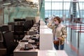 Woman with luggage over flight cancellation, stands at empty check-in counters at airport terminal due to coronavirus pandemic Royalty Free Stock Photo