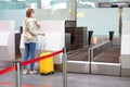 Woman with luggage over flight cancellation, stands at empty check-in counters at airport terminal due to coronavirus pandemic Royalty Free Stock Photo