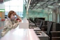 Woman with luggage over flight cancellation, stands at empty check-in counters at airport terminal due to coronavirus pandemic Royalty Free Stock Photo