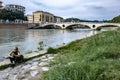 Woman lying on the banks of the river adige in Verona in the distance the bridge of victory, detail Royalty Free Stock Photo