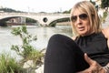 Woman lying on the banks of the river adige in Verona in the distance the bridge of victory, detail Royalty Free Stock Photo