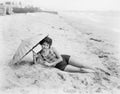 Woman lying at the beach with a sun umbrella Royalty Free Stock Photo