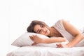 woman is lying in bed with her head on the pillow and hands under it. Royalty Free Stock Photo