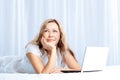 Woman lying on bed with laptop Royalty Free Stock Photo