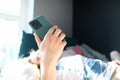 Woman lying bed and looking at smartphone screen Royalty Free Stock Photo