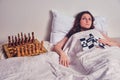 The woman is lying on the bed next to the chessboard and can not sleep. Problems in life in a smart independent woman, concept