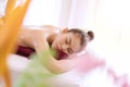 Woman lying on the bed with oil on her back while enjoying recipe spa therapy body in spa salon. Face of female sleep Royalty Free Stock Photo