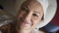 A woman lying on the bed and relaxing in spa salon. Action. Close up top view of relaxed and smiling female face with a Royalty Free Stock Photo