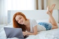 Woman lying on the bed and using laptop computer Royalty Free Stock Photo