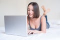 Woman lying on the bed and using laptop Royalty Free Stock Photo