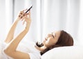 woman lying on the bed and watching the mobile phone Royalty Free Stock Photo