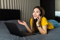 Woman lying on bed, working on laptop, calling. Home office Royalty Free Stock Photo