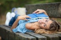 woman lying on bench reading book in park Royalty Free Stock Photo