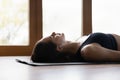 Woman lying in Dead Body asana listen music through earbuds Royalty Free Stock Photo