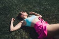 Woman lying down in grass day dreaming in summer. Feeling good optimism. Healthy gorgeous pretty model relaxing in carefree mood.