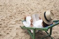 A woman lying down and reading book on the beach chair with feeling relaxed Royalty Free Stock Photo