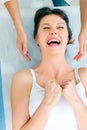 woman lying down smiling and receiving head massa