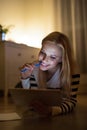 Woman lying on the floor, working on tablet at night. Royalty Free Stock Photo