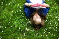 Woman lying on grass with book