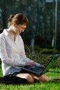 Woman lying on grass with laptop Royalty Free Stock Photo