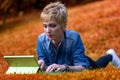 Woman, lying, grass, laptop-tablet combo, nature, work, broadban Royalty Free Stock Photo