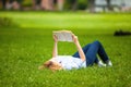 Woman lying in grass and reading a book Royalty Free Stock Photo