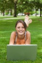 Woman lying on grass and using laptop Royalty Free Stock Photo